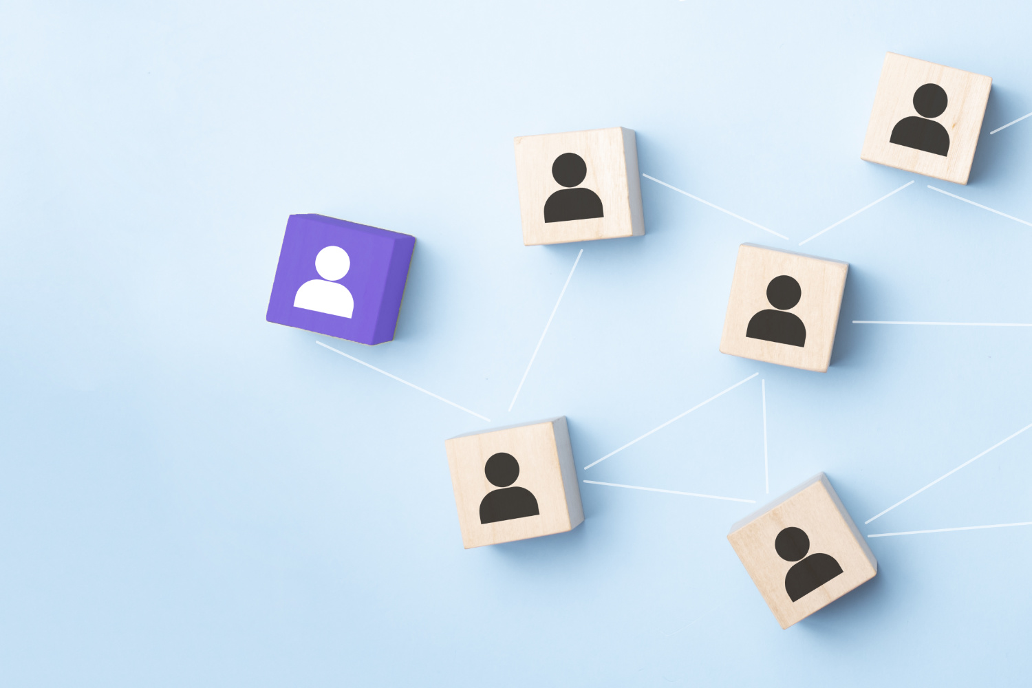 Holzwürfel, die mit der Silhouette einer abstrakten Person bedruckt sind, werden durch Linien verbunden.